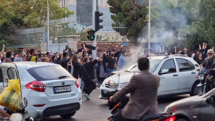 Protesters walking amid cars in the street and on the sidewalk