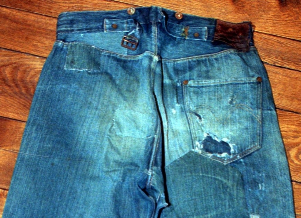 a torn, slightly faded, and dirty pair of jeans