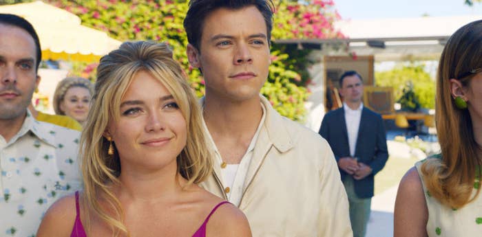 Florence Pugh and Harry Styles stand next to each other outside in a scene from the film