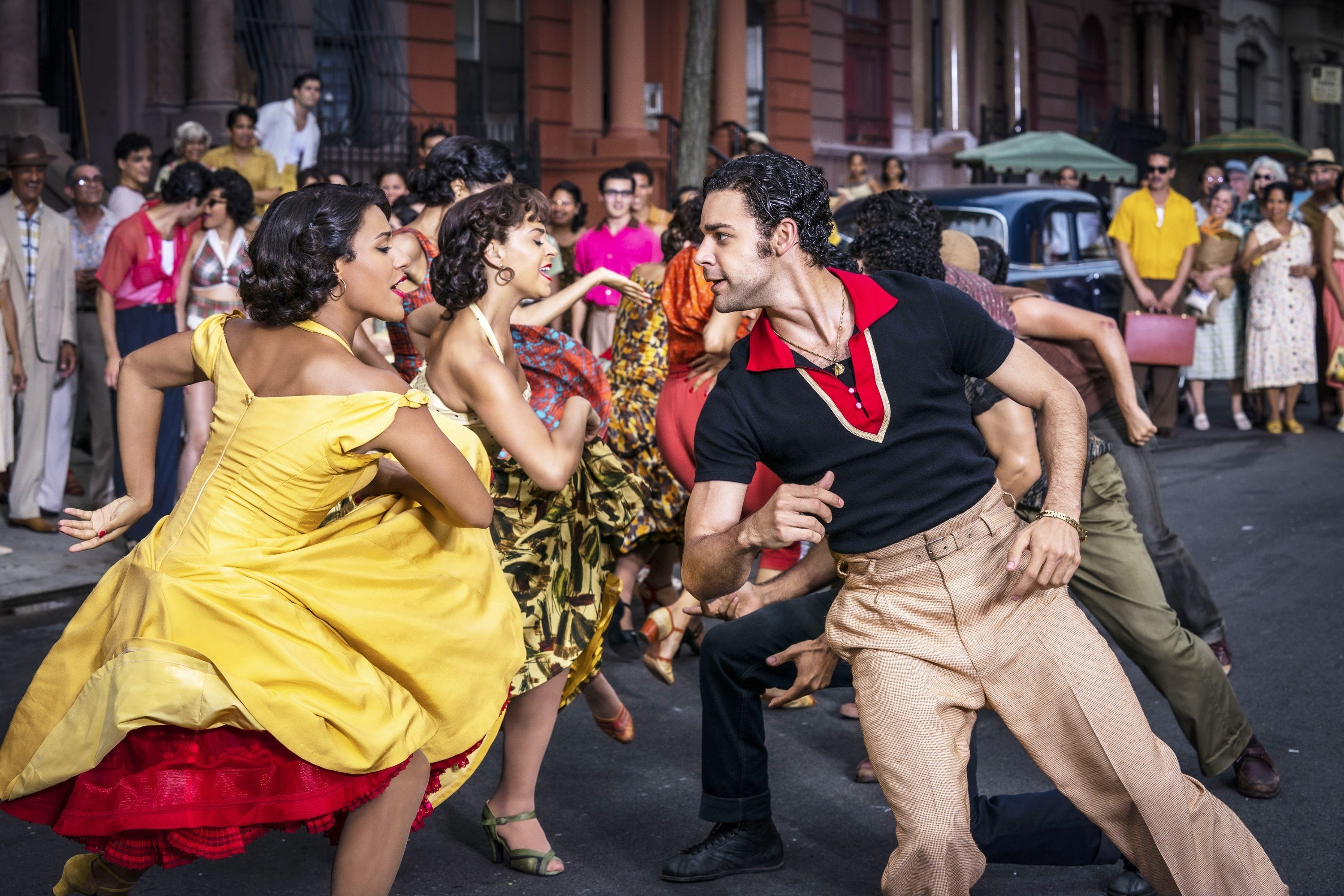 A crowd of people dance in colorful clothing
