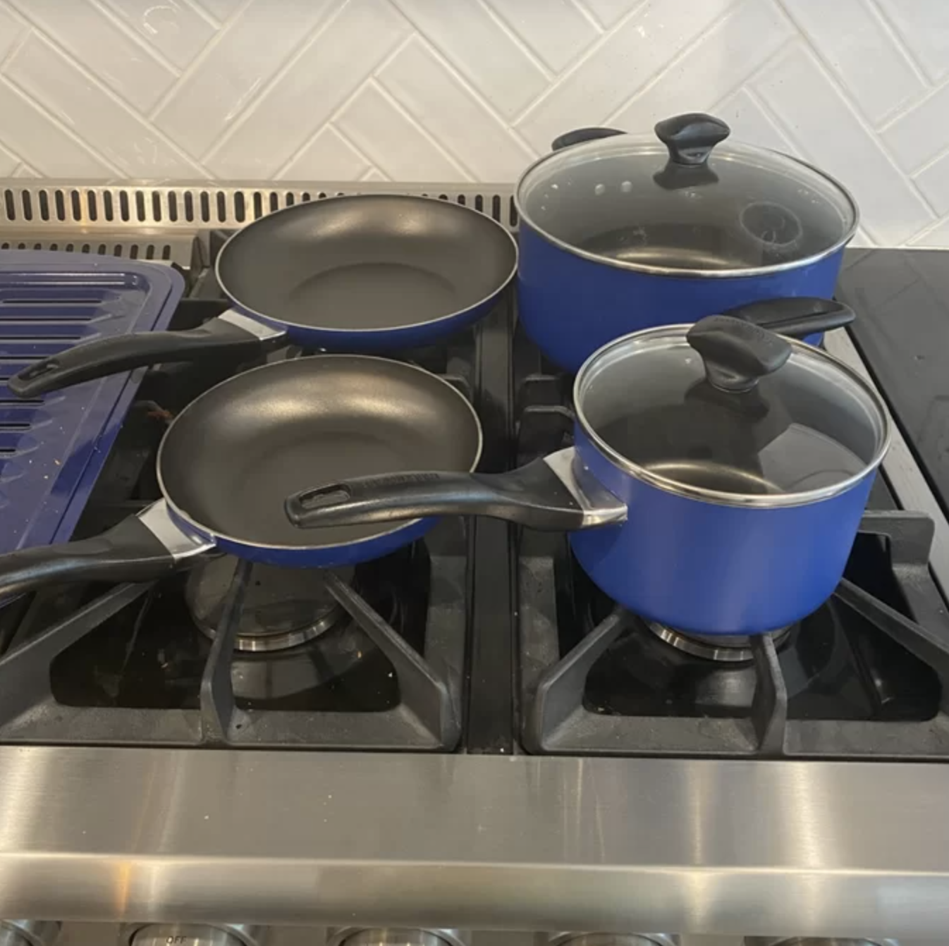 the set of cookware on a reviewer&#x27;s stove in the dark blue color