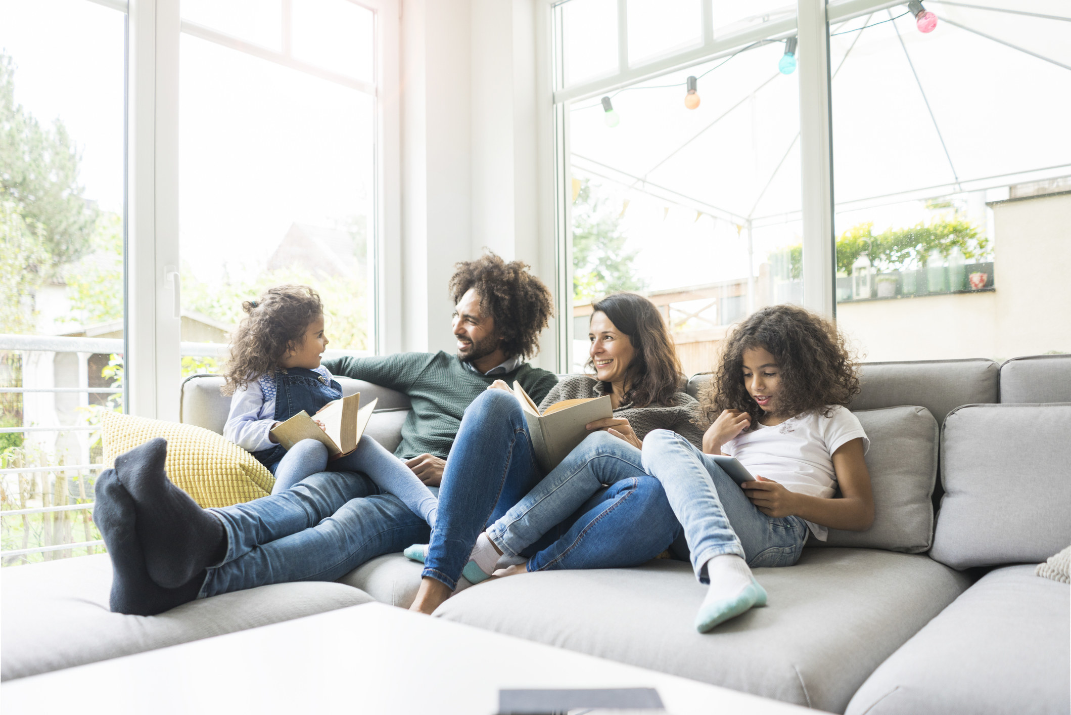 Family sitting on couch and reading books