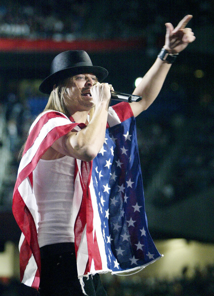 Kid Rock wearing a US flag and performing