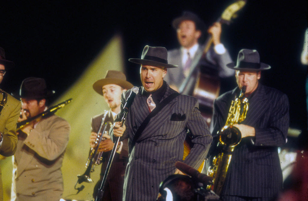 Men in suits and wide-brimmed hats performing
