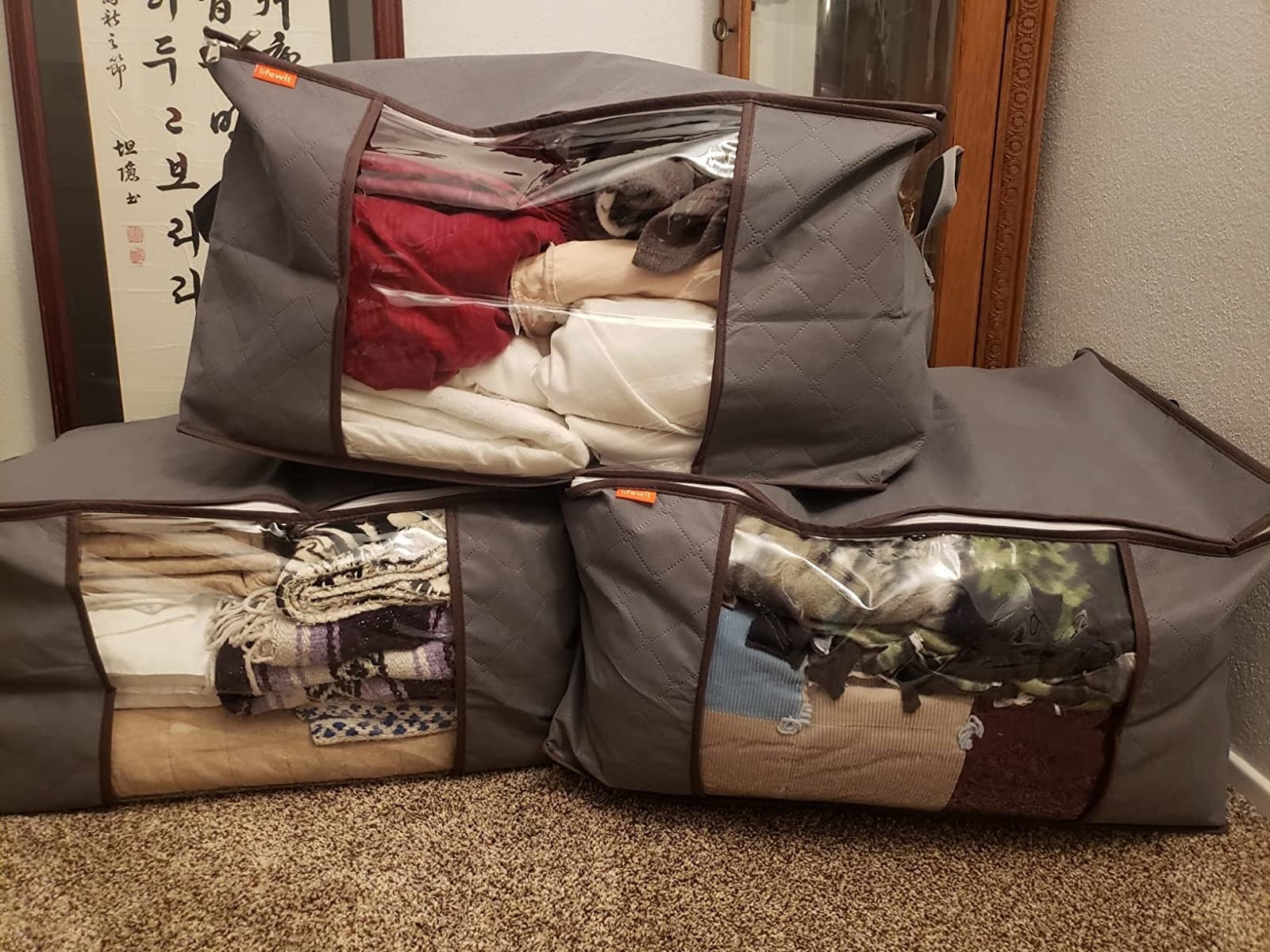 Reviewer image of three storage bags packed with clothing and blankets
