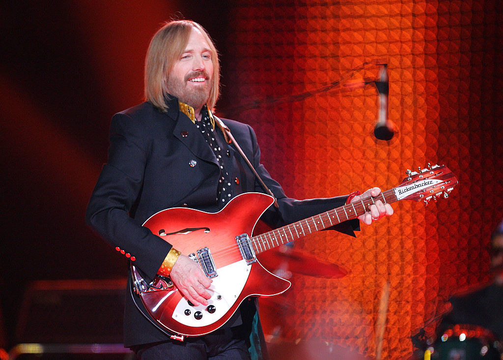 Tom smiling and playing guitar