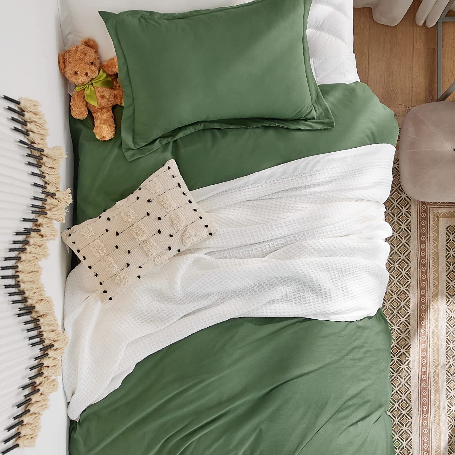 a white blanket on a green bed set