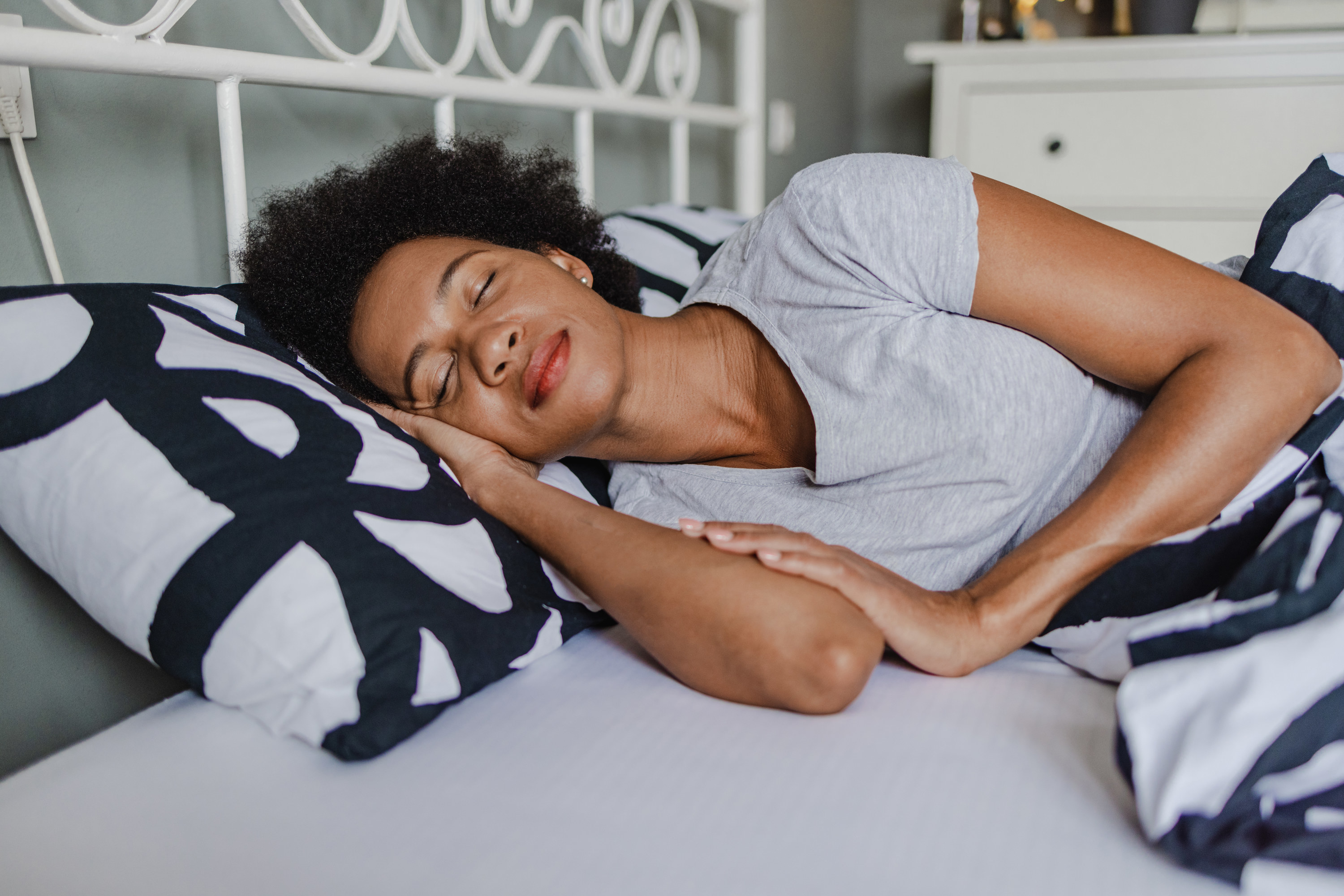 A woman wearing a gray v-neck tee takes a nap