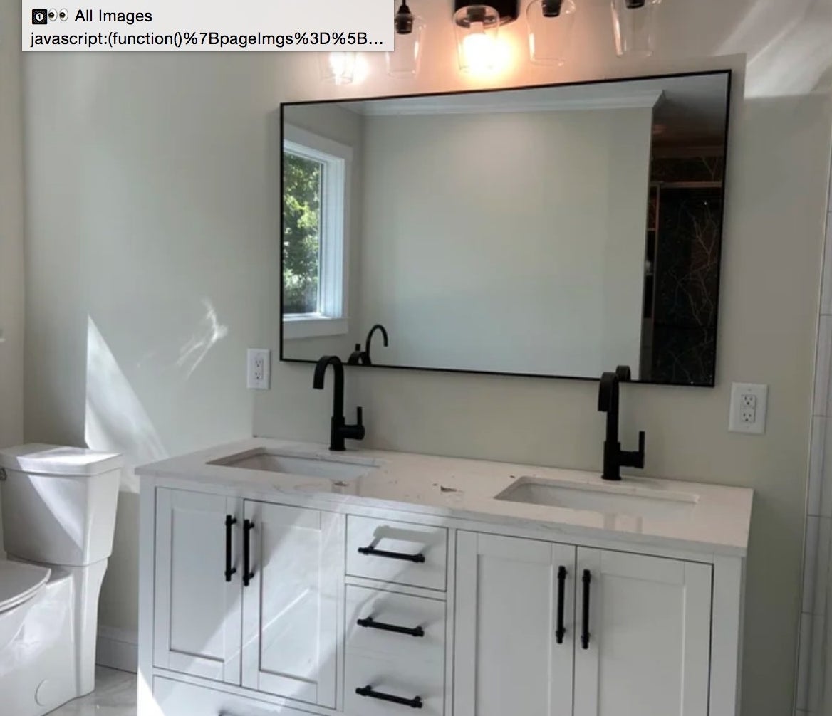Large rectangular black finished mirror over white bathroom vanity/sink