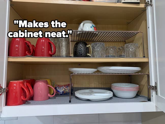 A cabinet with added shelves stacked with dishes