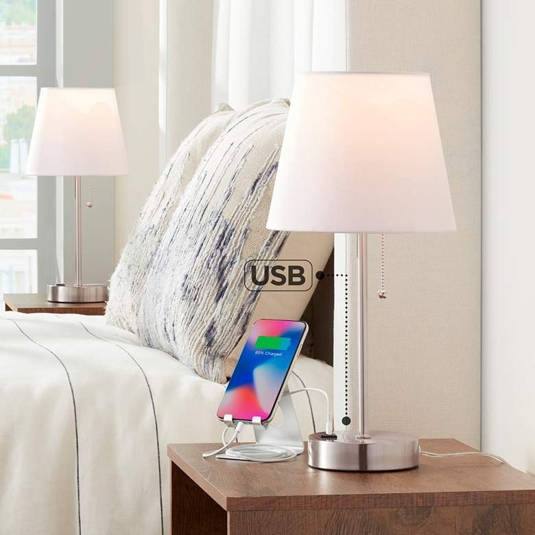 a pair of table lamps on two nightstands, with a phone plugged into the USB port of one of the lamps