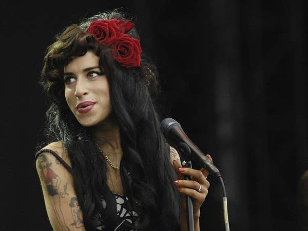 Winehouse smiling and holding a mic