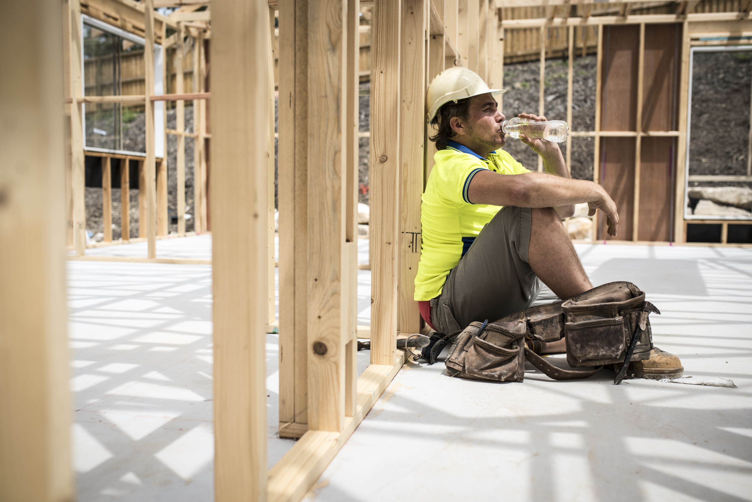 A construction worker takes a break and sips some water