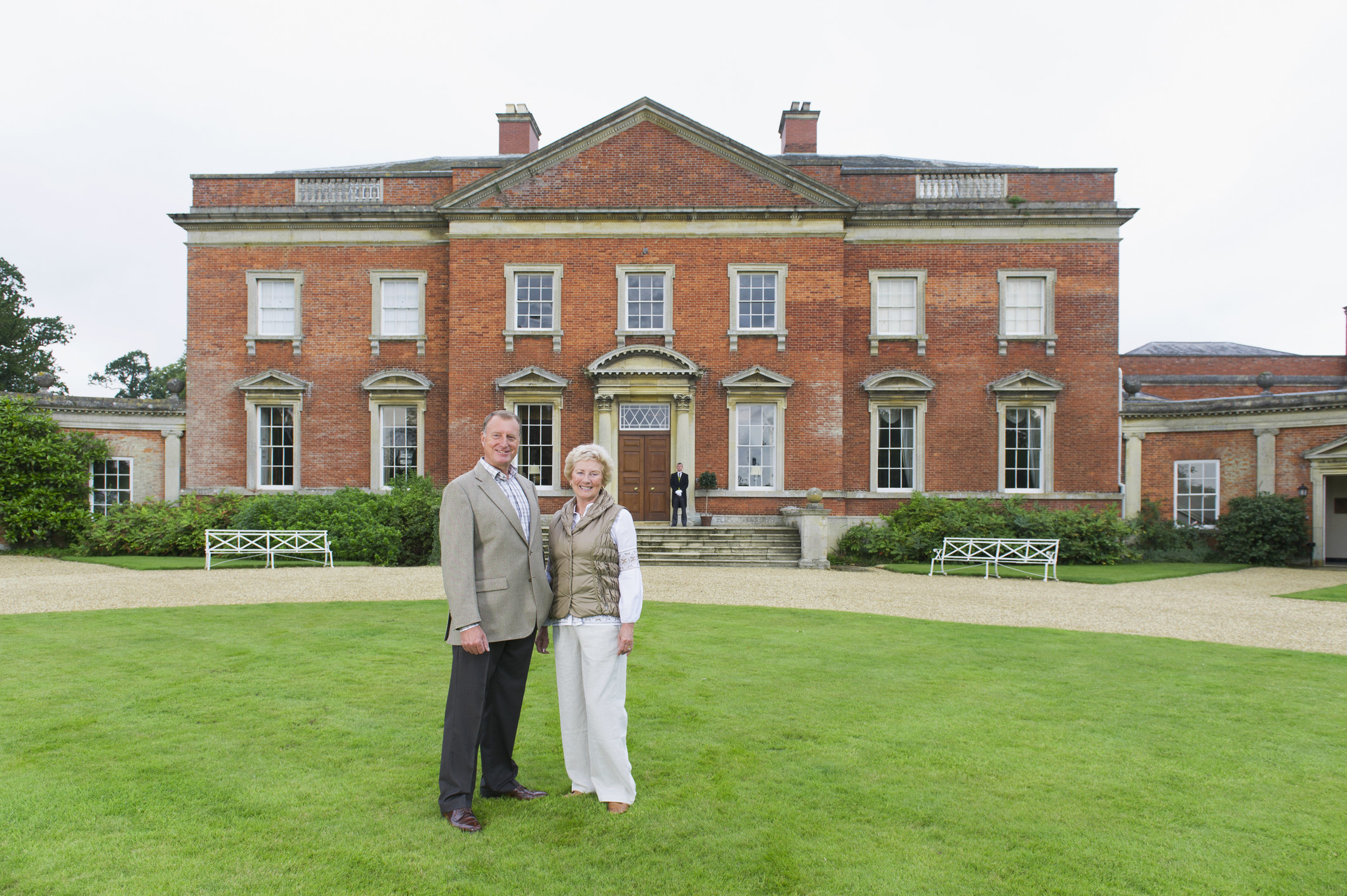 A couple in front of lavish estate