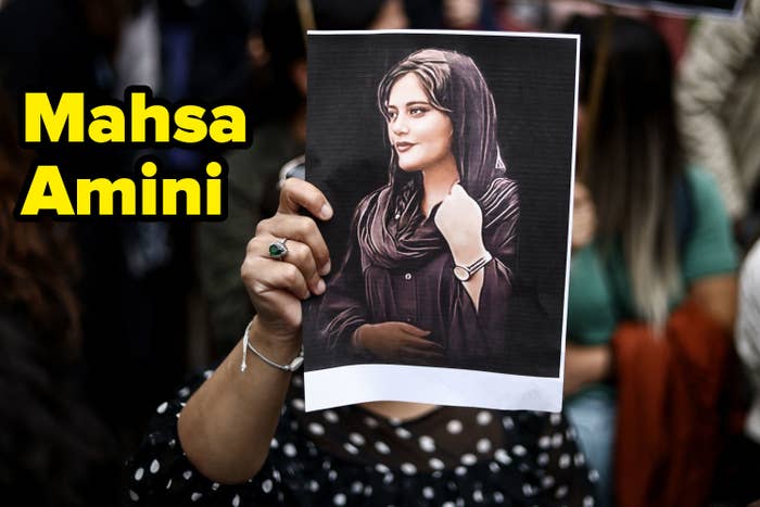 A person holding up a picture of Mahsa