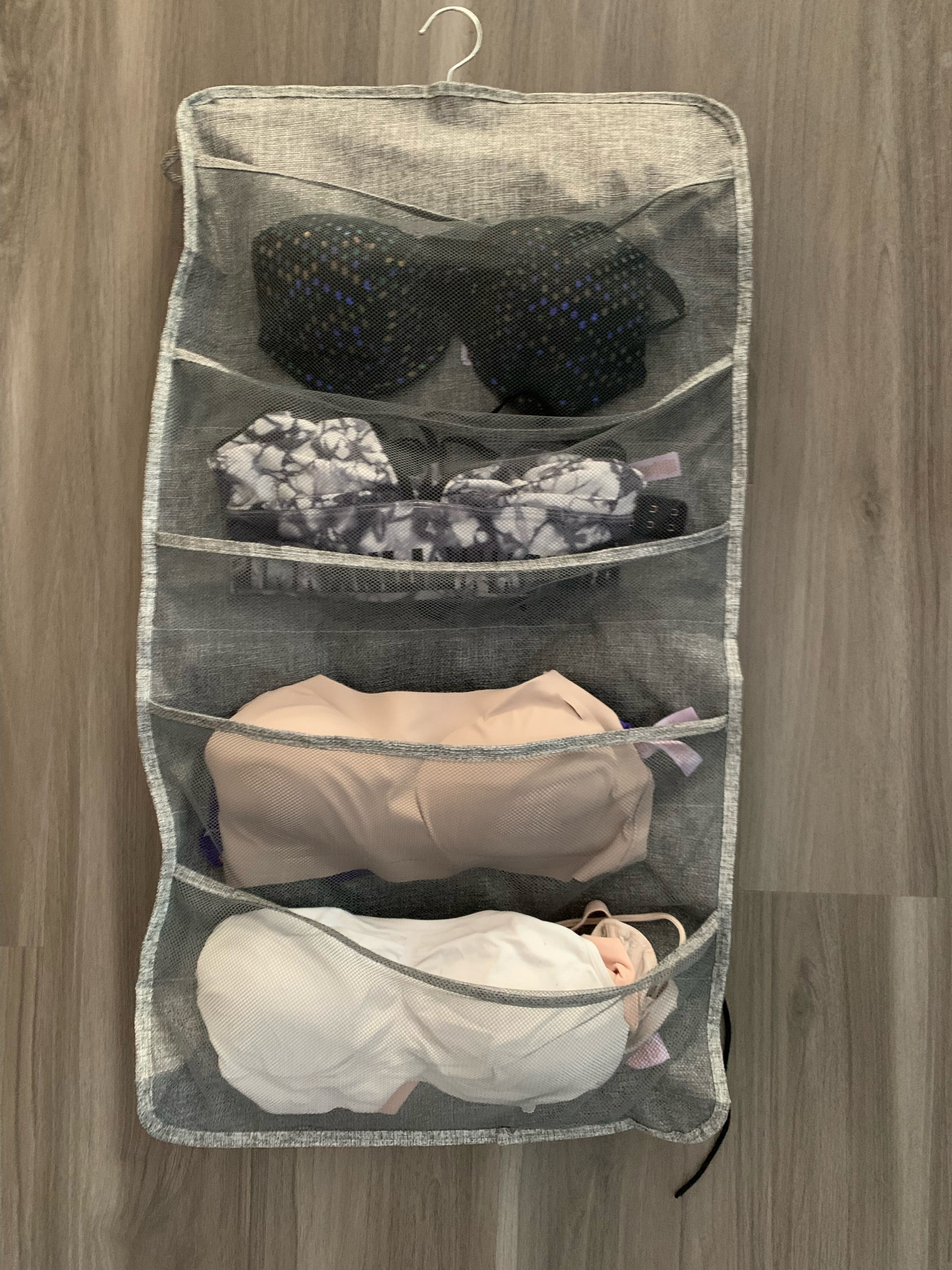 A hanging closet organizer filled with bras