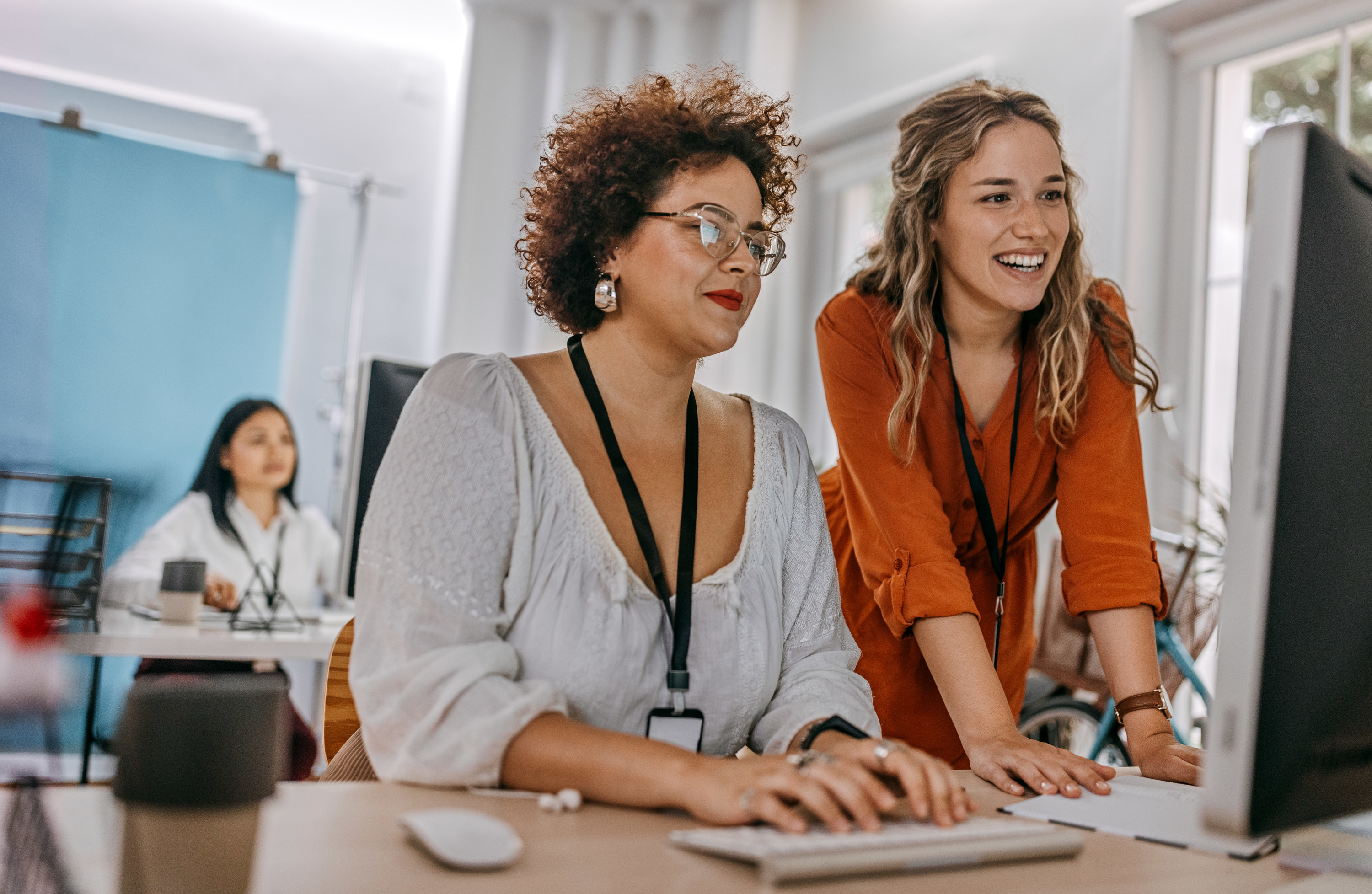 Two women work on a computer in their office