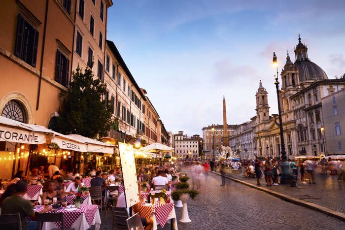 Italy, Lazio, Rome, People dining outside in Piazza Navona in twilight