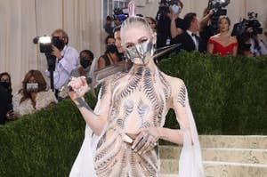 Grimes wearing a sheet dress and carrying a sword