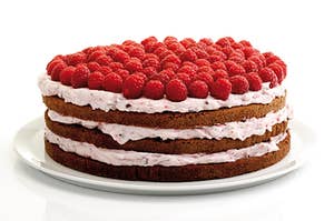 a layered cake topped with raspberries