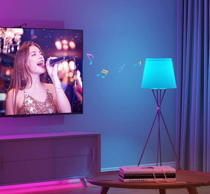 a person singing on the TV screen while the lightbulb in a lamp syncs with the music