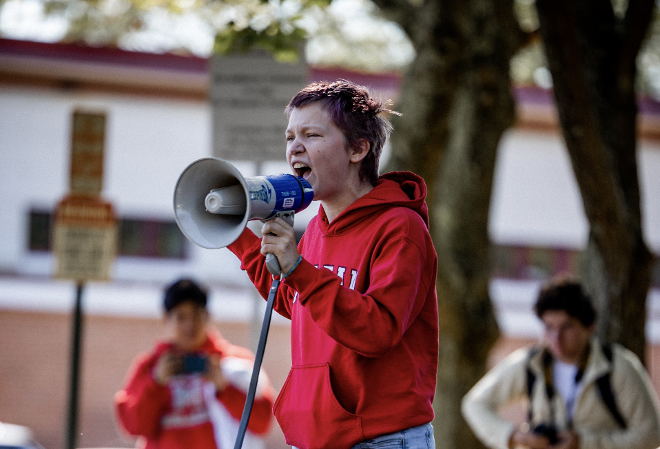 A student activist yells into a megaphone 
