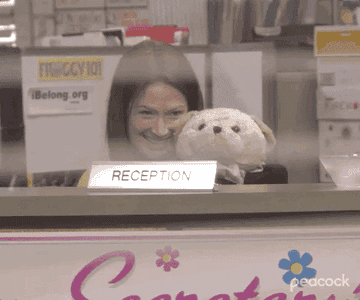 receptionist using a dressed-up teddy bear to wave at the office