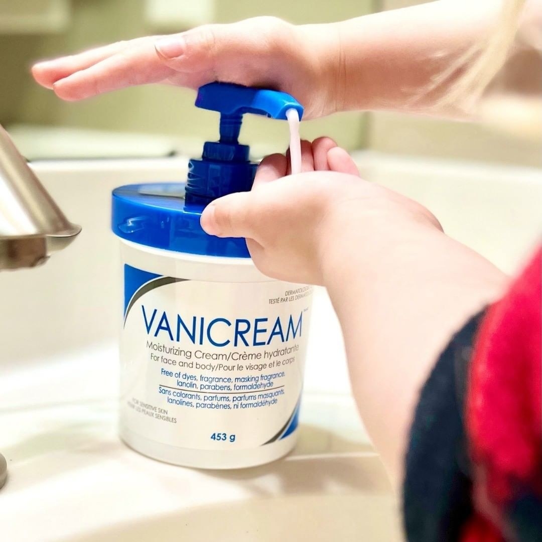 a hand using the skin cream through its pump top