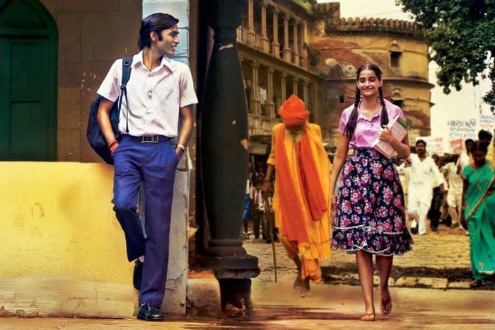 Dhanush looks over as Sonam Kapoor walks past him on the streets of Varanasi