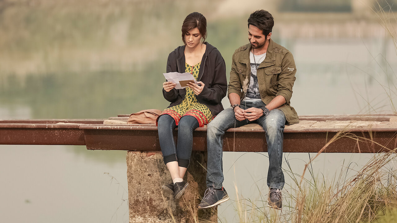 Kriti Sanon and Ayushmann Khurrana sitting on a lake side and reading a letter in a still from the film