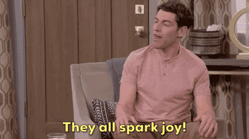 a gif of max greenfield shouting they all spark joy
