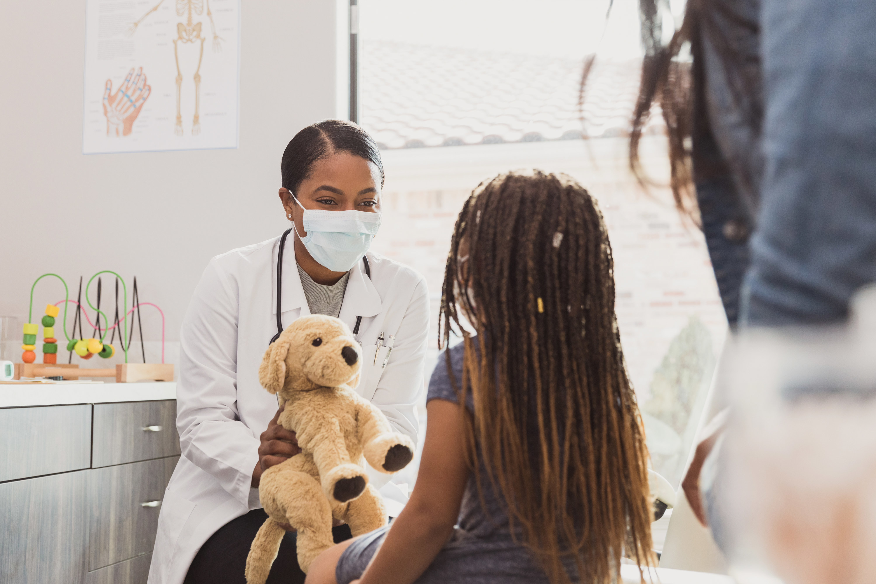 a doctor showing a toy to a kid