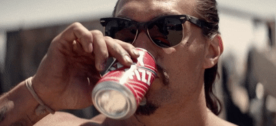 A man drinking a beverage from a can