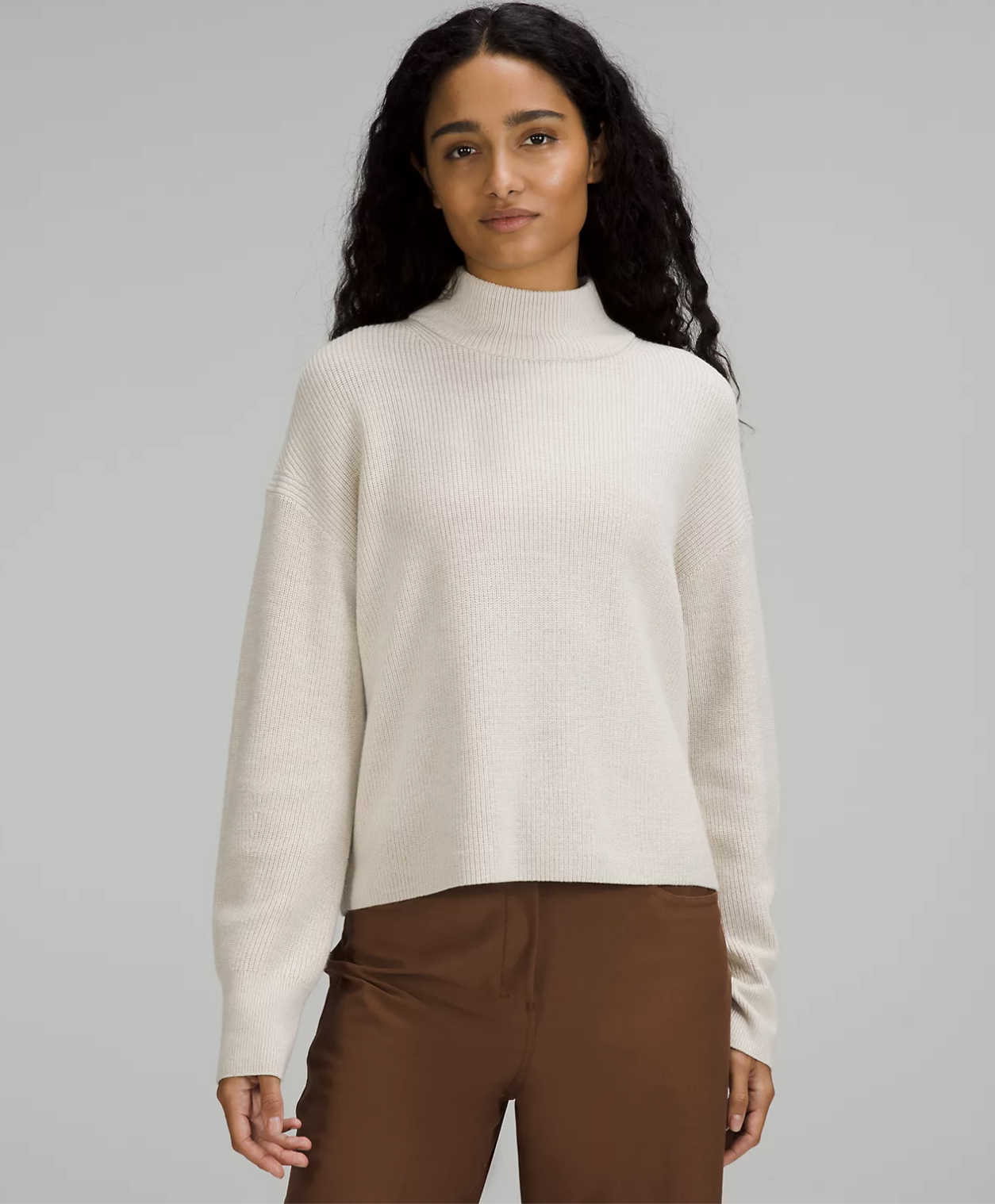 A person wearing the sweater with utility pants