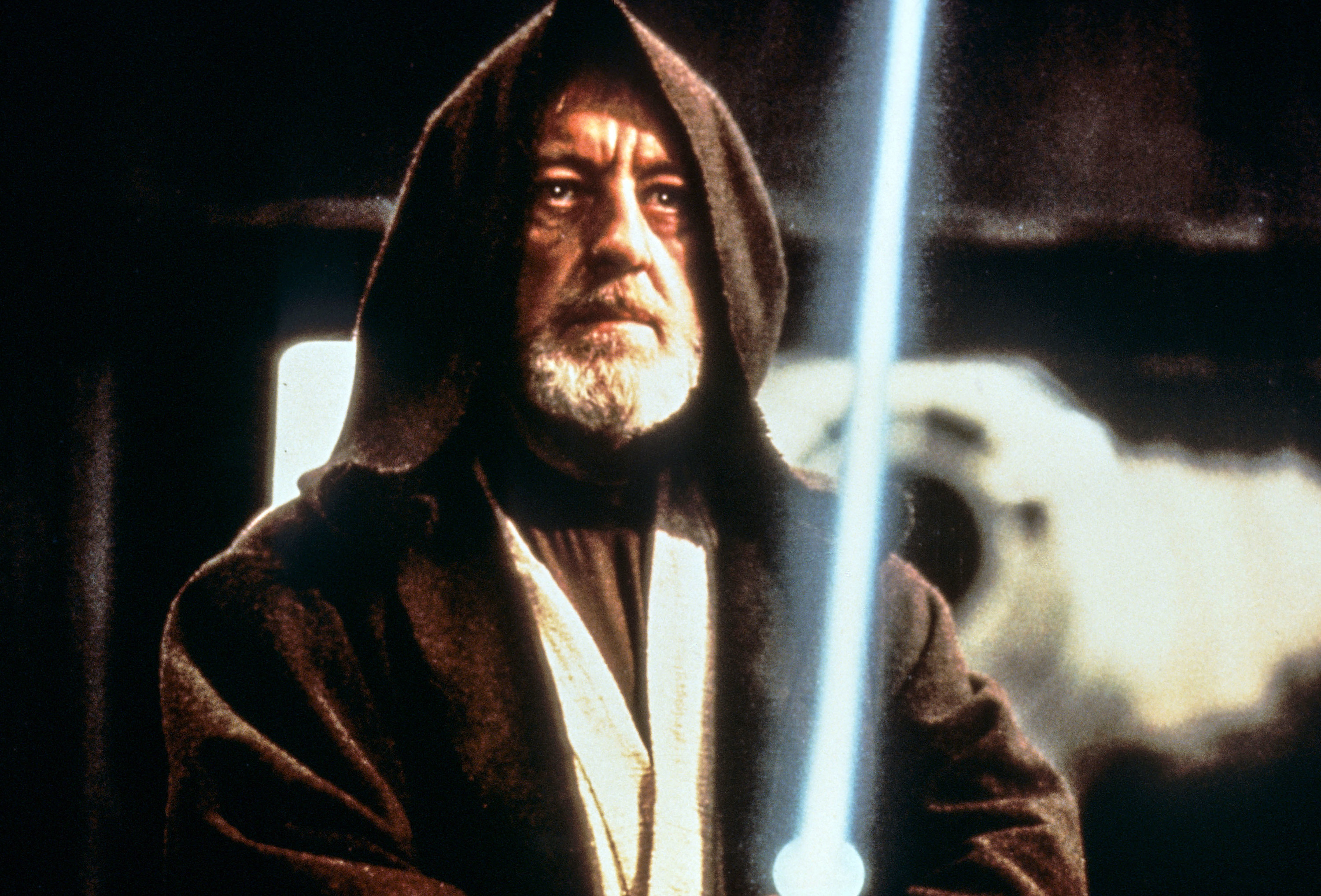 closeup of Guinness&#x27;s character holding a lightsaber