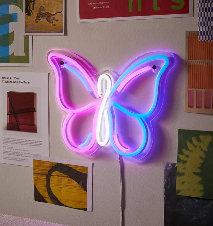 the neon butterfly sign on a wall