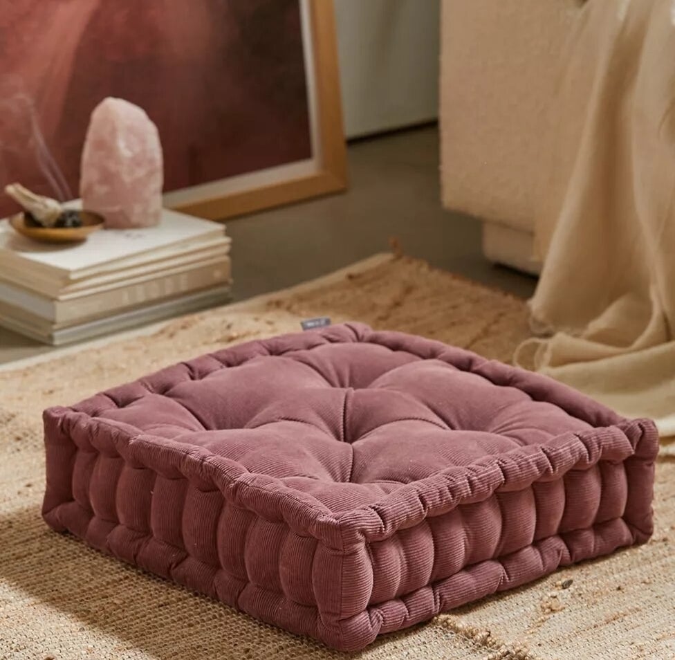 the cushion on the floor on top of a rug