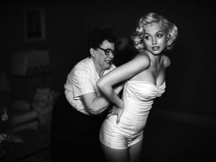 Ana de Armas as Marilyn Monroe being helped into an outfit