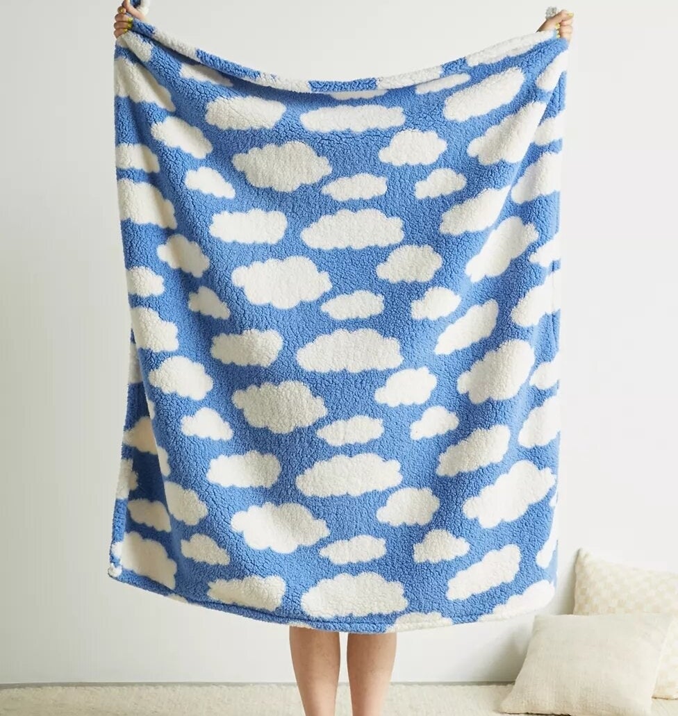 someone holding the throw blanket up