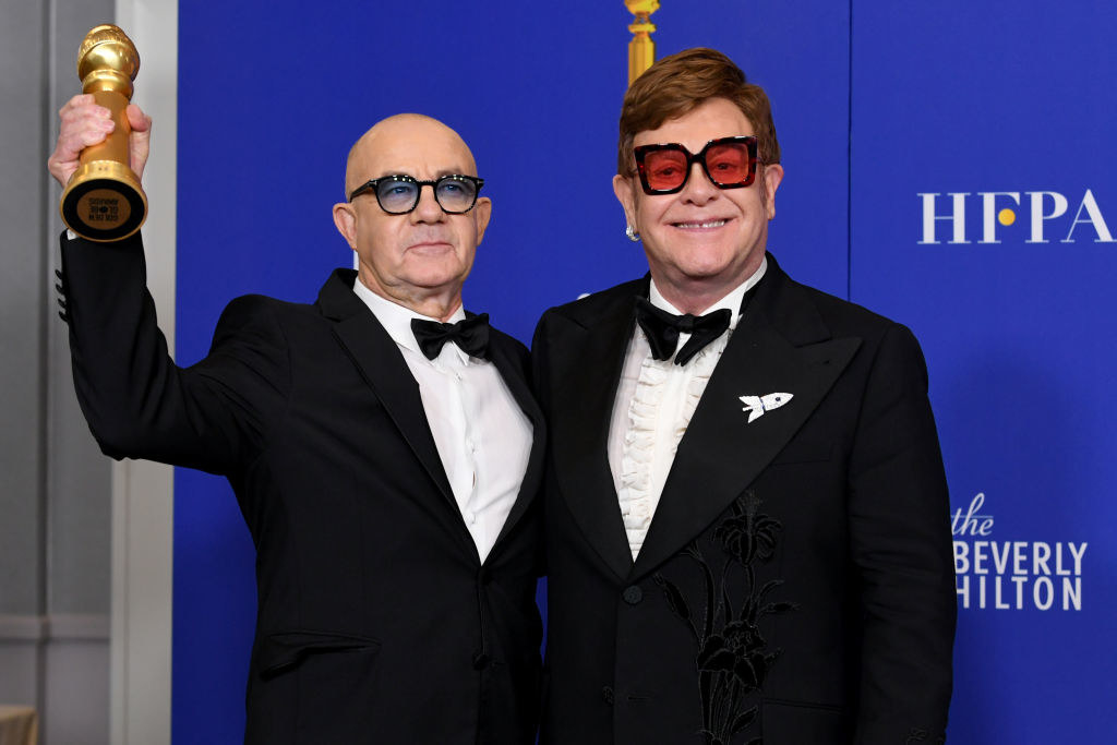 Bernie Taupin and Elton John in suits and bow ties