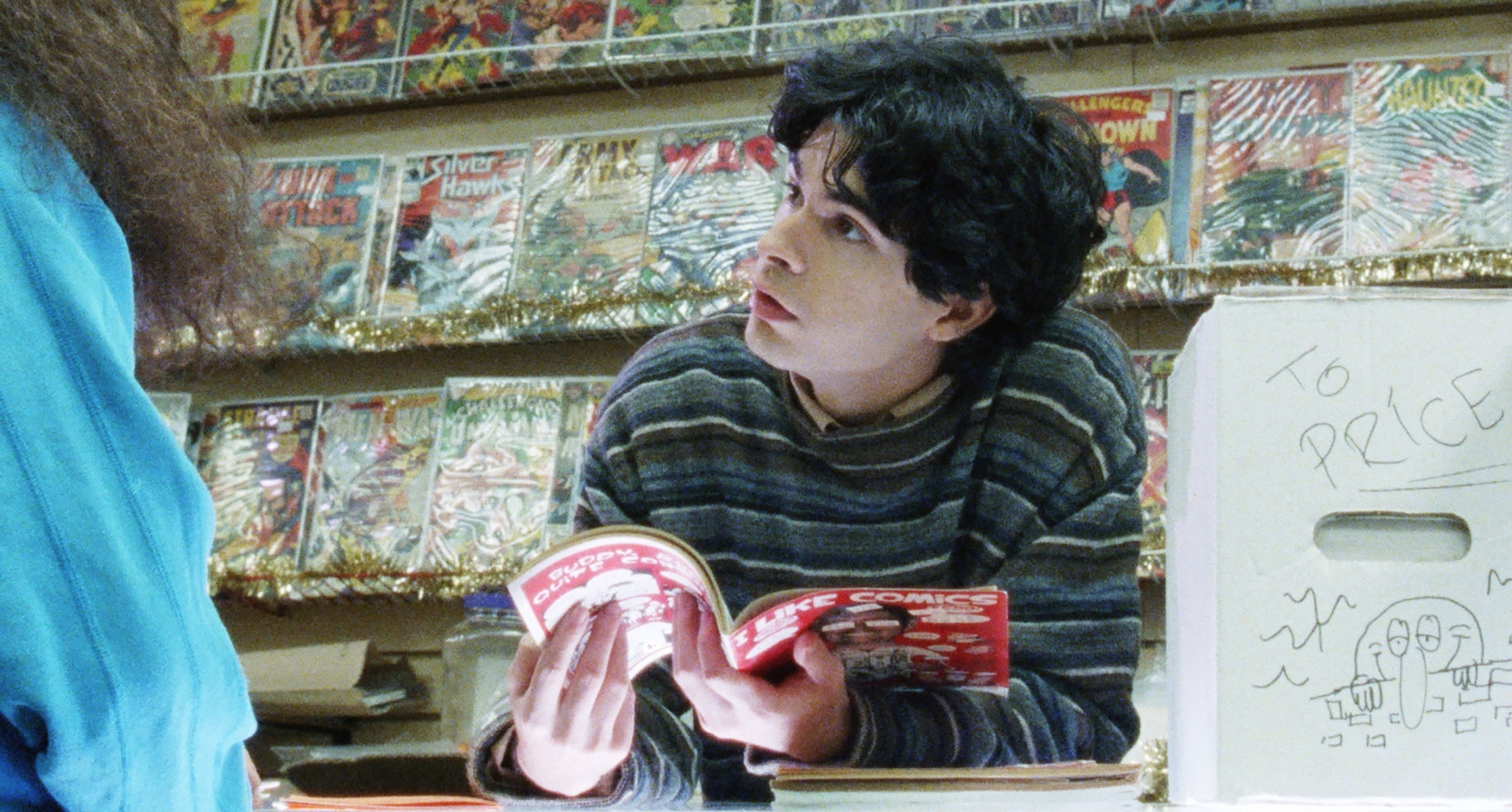 Daniel Zolghadri reads a magazine at a counter