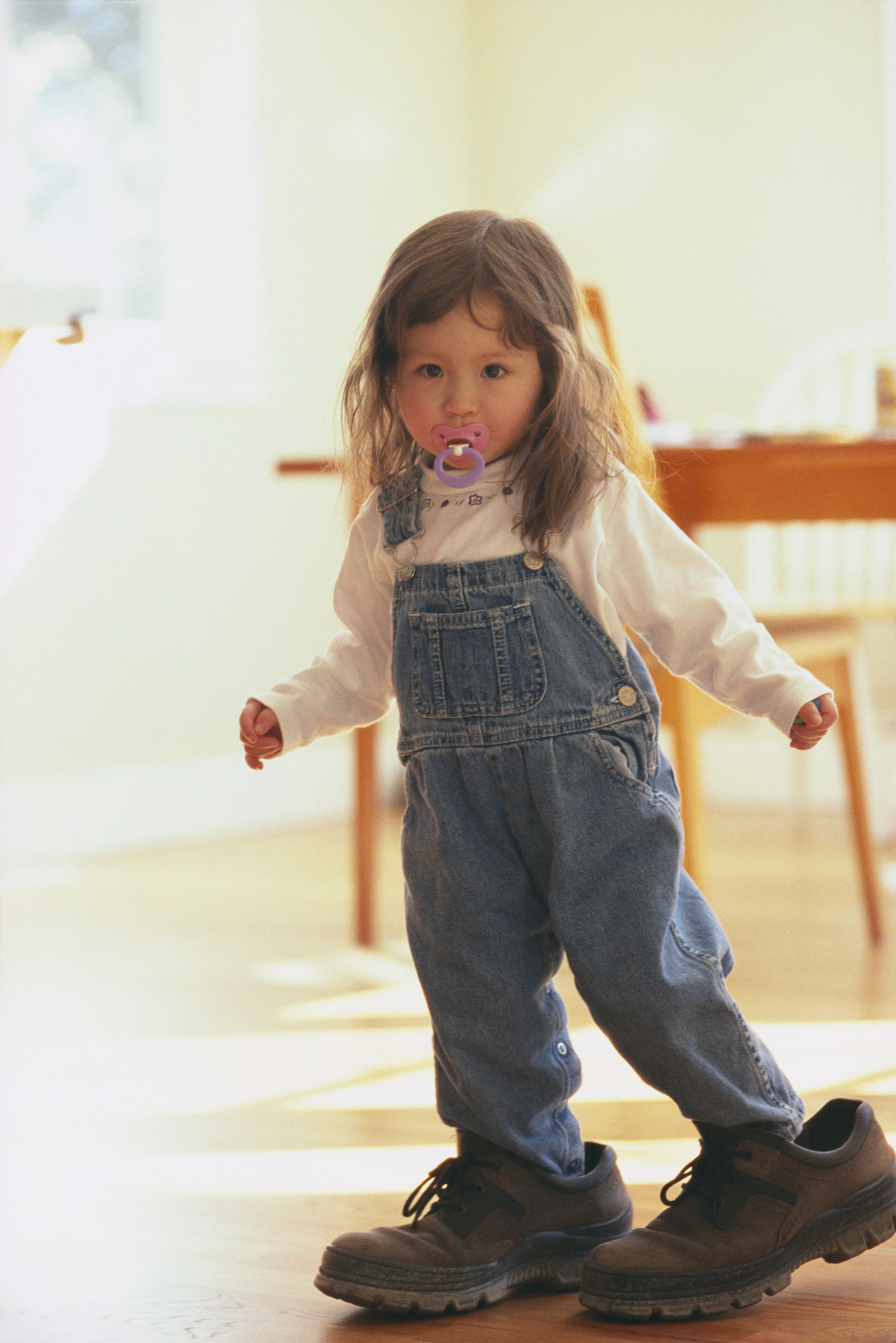 Toddler girl walking around in her dad&#x27;s shoes