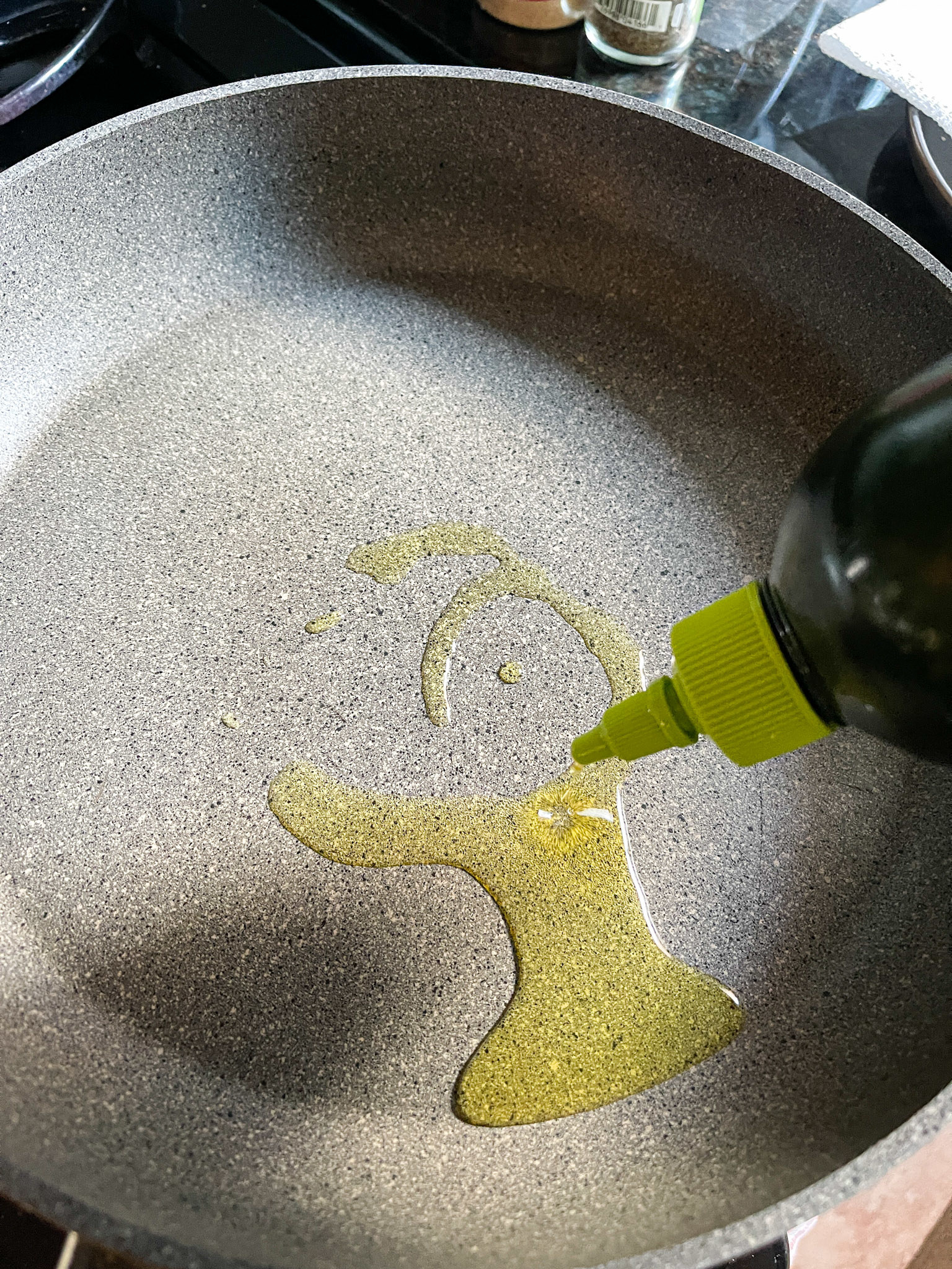 Someone putting oil on a pan