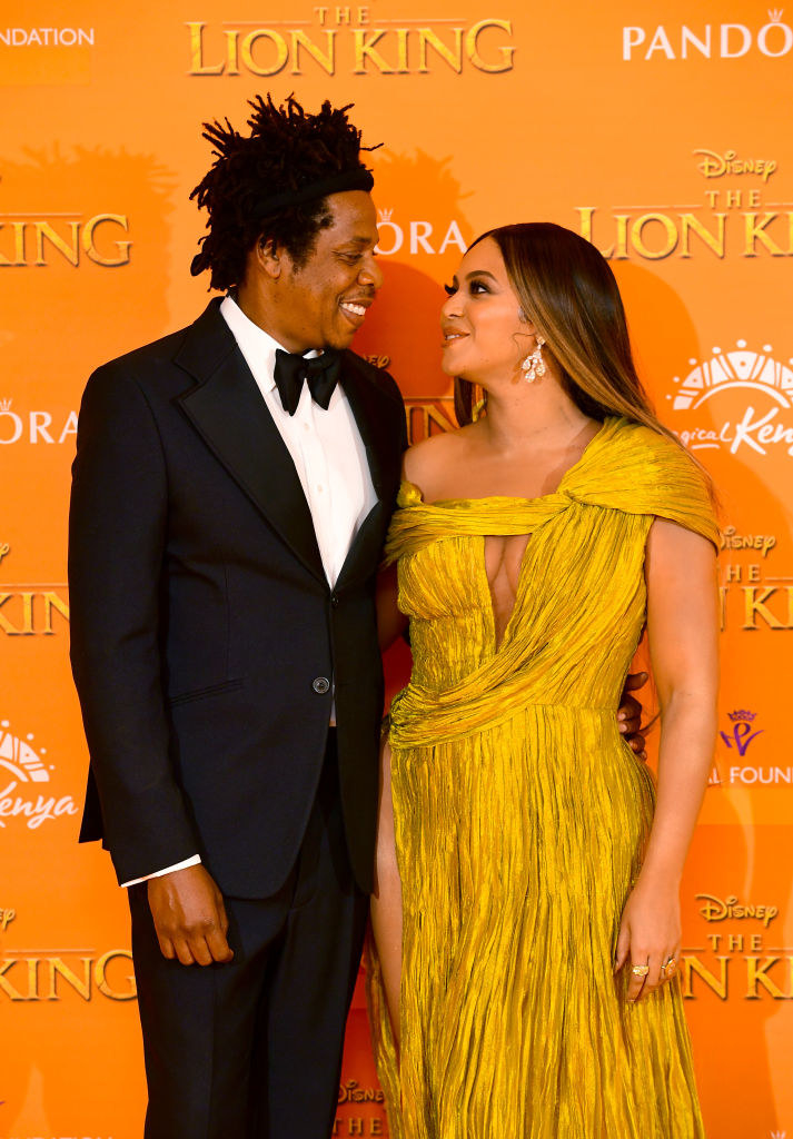 the couple looking at each other while at the Lion King premiere