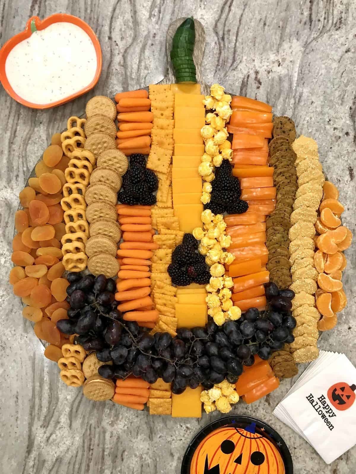 A board of snacks shaped into a pumpkin.