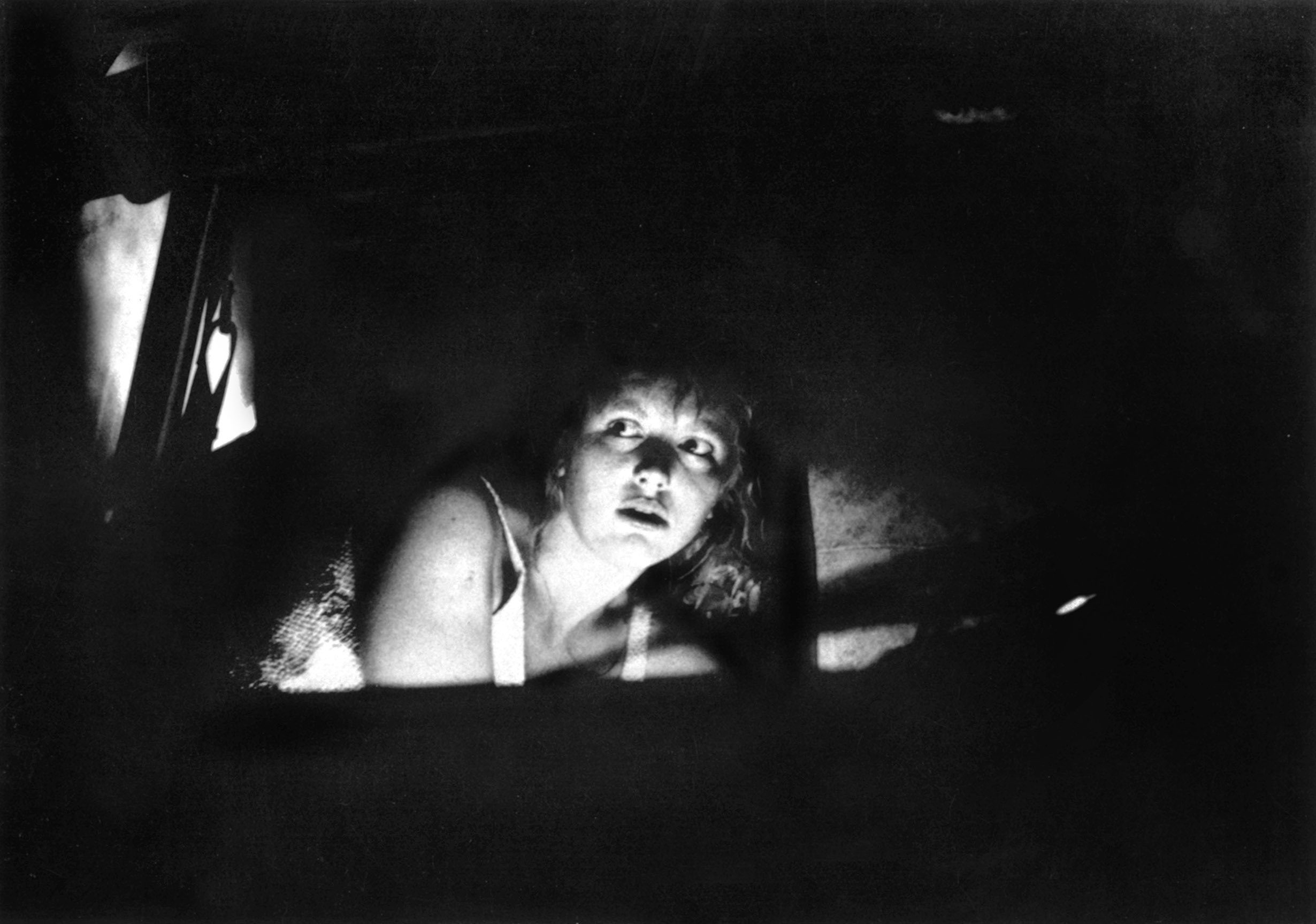 A woman crawls around in the dark