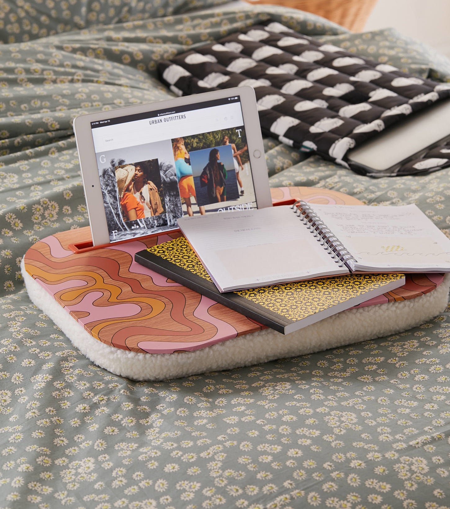 a cute lap desk with books and a tablet on it on a bed
