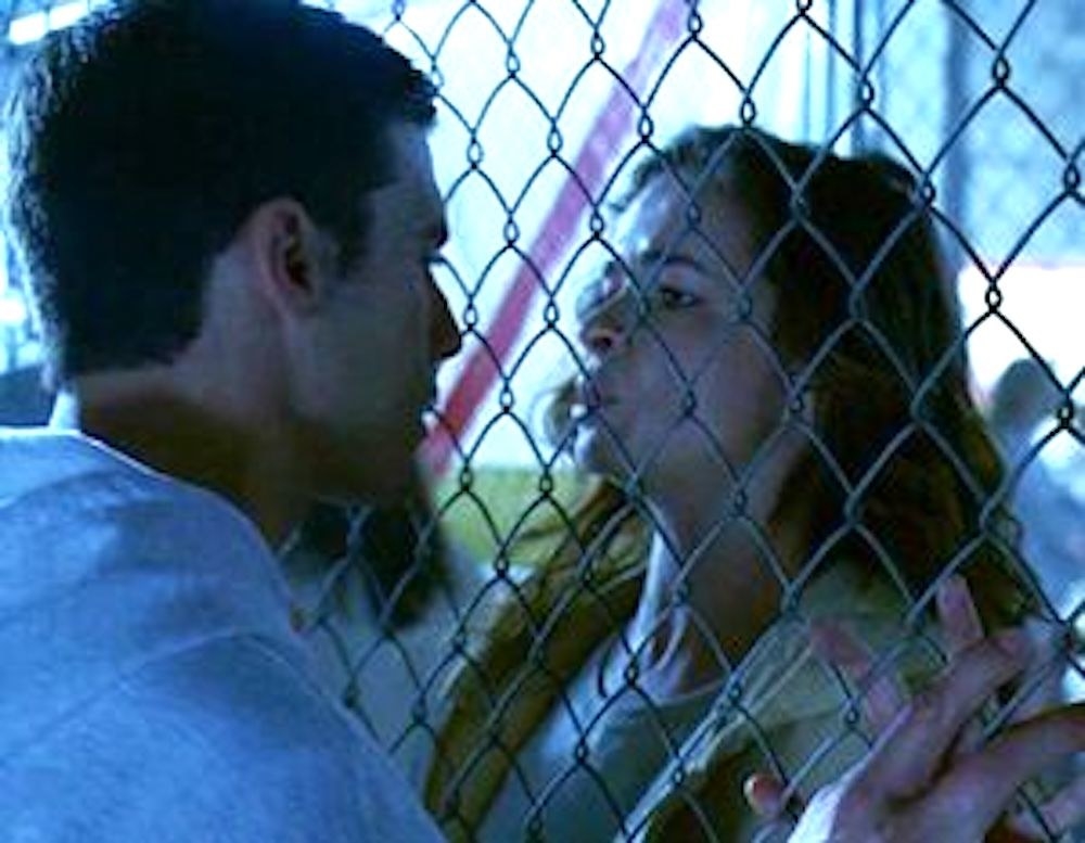Peter and Caitlin talking to each other with a fence between them