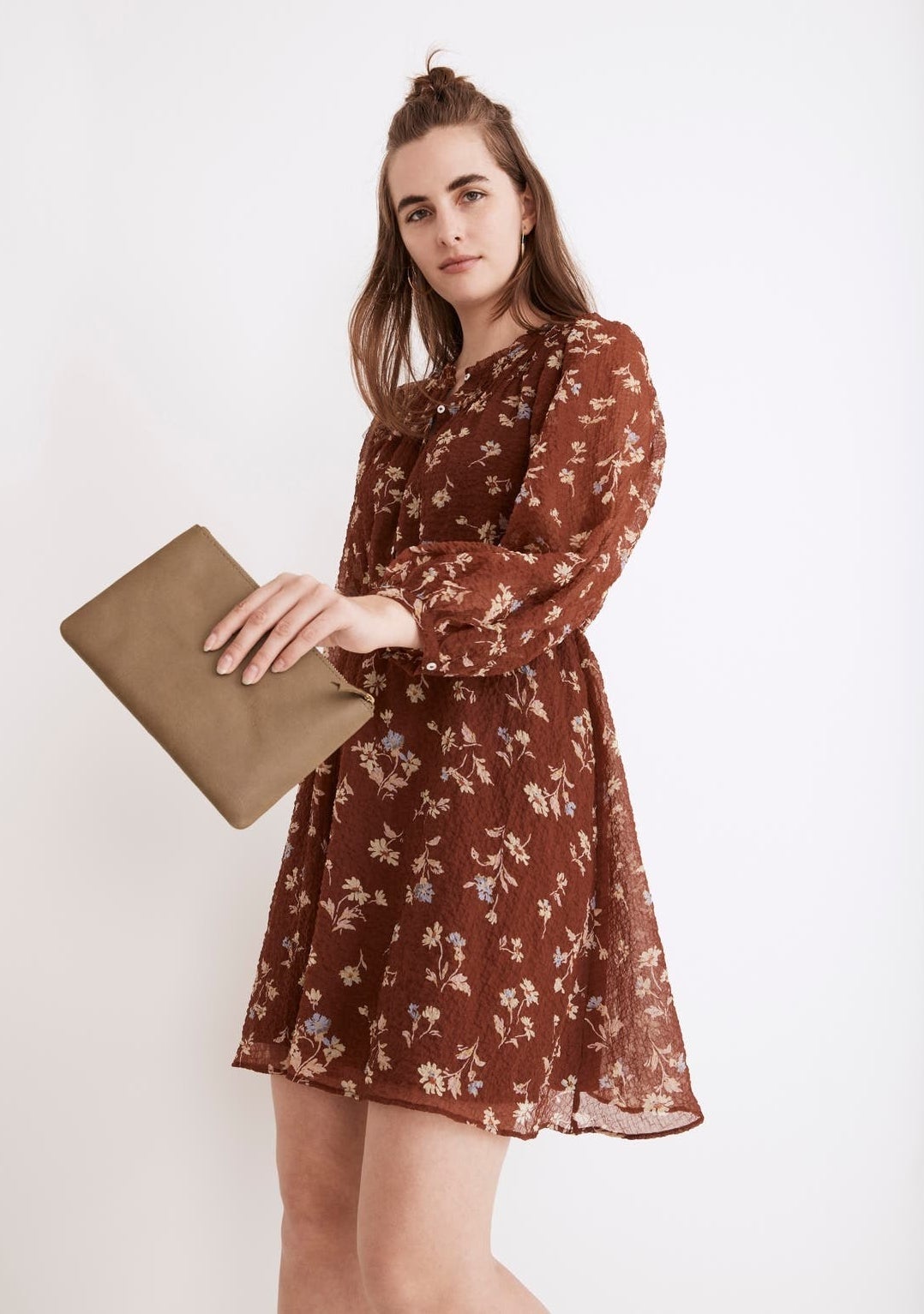 Model in a dress holding out the leather pouch