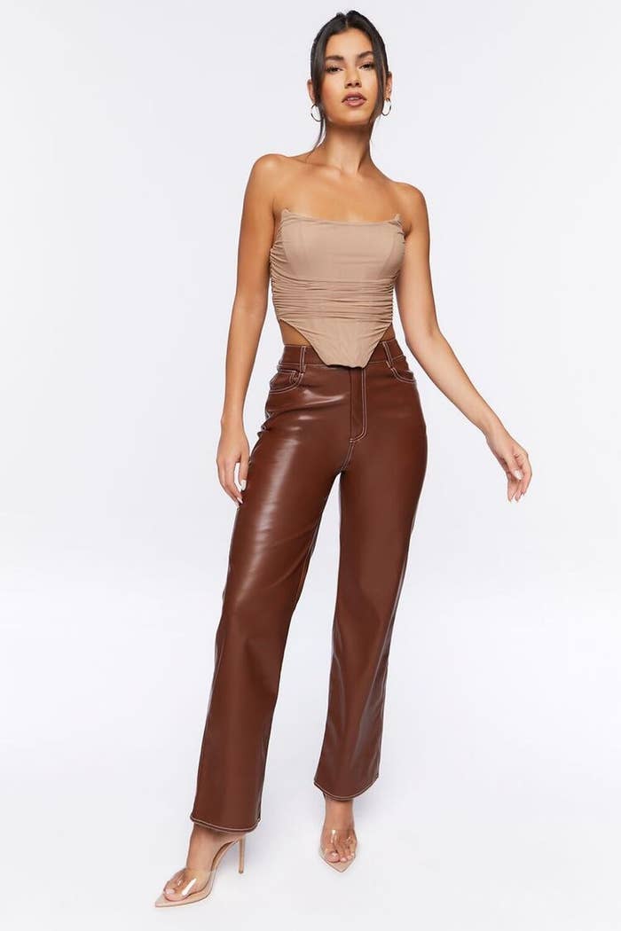 Model wearing brown faux leather pants